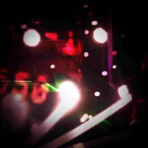 room barely-lit by the faintest sliver of dying sunlight cast from the perimeter of blinds covering a window