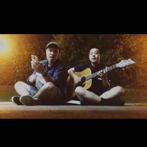 和萧华坐在街边弹吉他